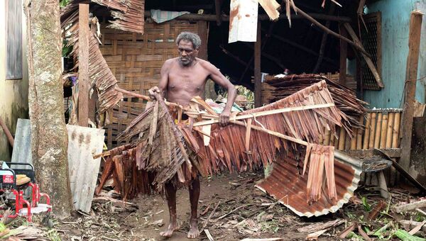 Житель столицы Вануату Порт-Вилы ликвидирует последствия циклона Пэм