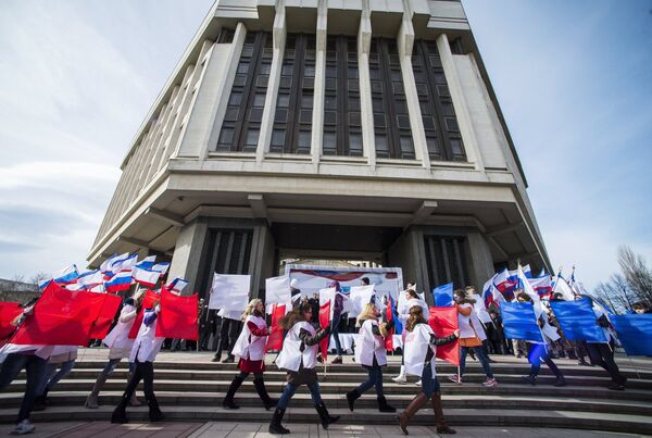 Участники торжественного митинга по случаю празднования годовщины Крымской весны на площади у Государственного Совета РК в городе Симферополе