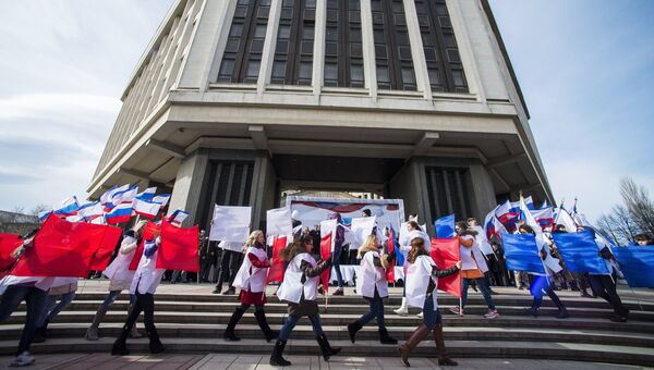 Участники торжественного митинга по случаю празднования годовщины Крымской весны на площади у Государственного Совета РК в городе Симферополе