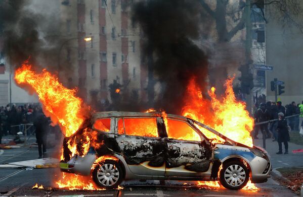 Горящая полицейская машина во время беспорядков устроенных антикапиталистическим движением Blockupy