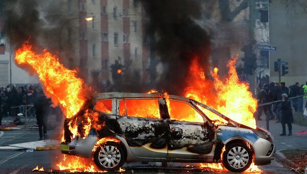 Горящая полицейская машина во время беспорядков устроенных анти-капиталистическим движением Blockupy
