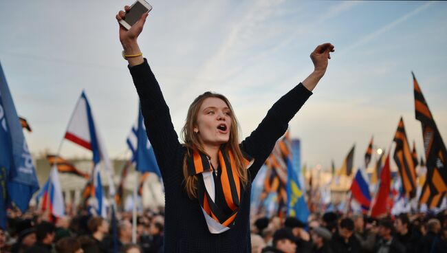 Участники митинга-концерта, посвященного годовщине воссоединения Крыма с Россией, на Васильевском спуске Москвы