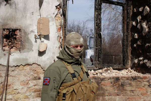 Ополченец ДНР у разрушенного здания в Донецке