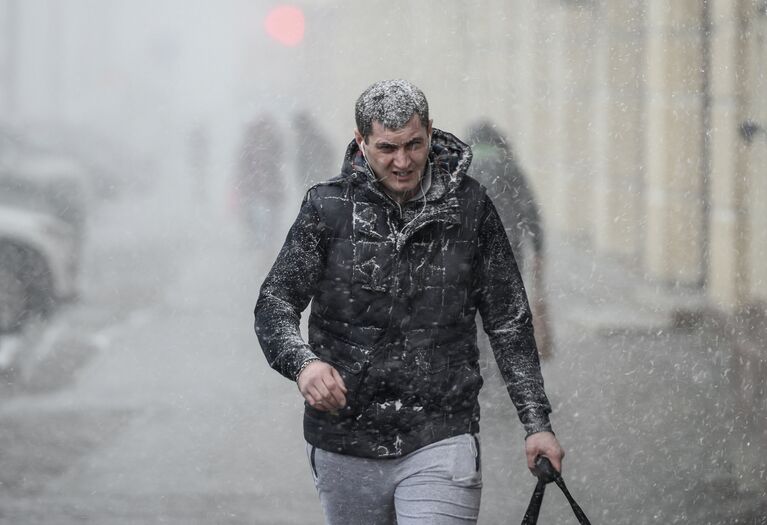 Прохожий на улице во время снегопада в Москве