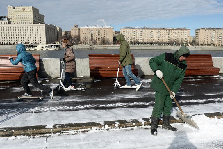 Сотрудник служб ЖКХ убирает снег