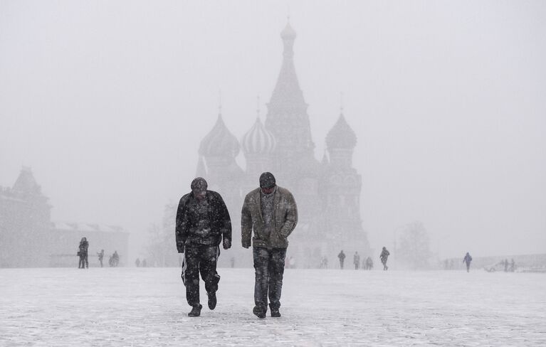 Жители столицы на Красной площади во время снегопада в Москве