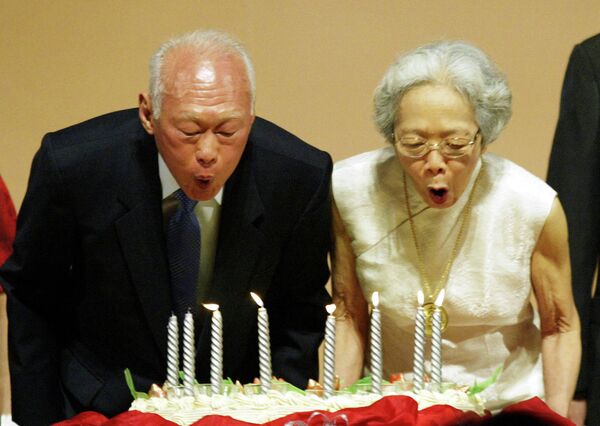 Бывший премьер-министр Сингапура Ли Куан Ю с супругой задувают свечи на праздновании 80-летия