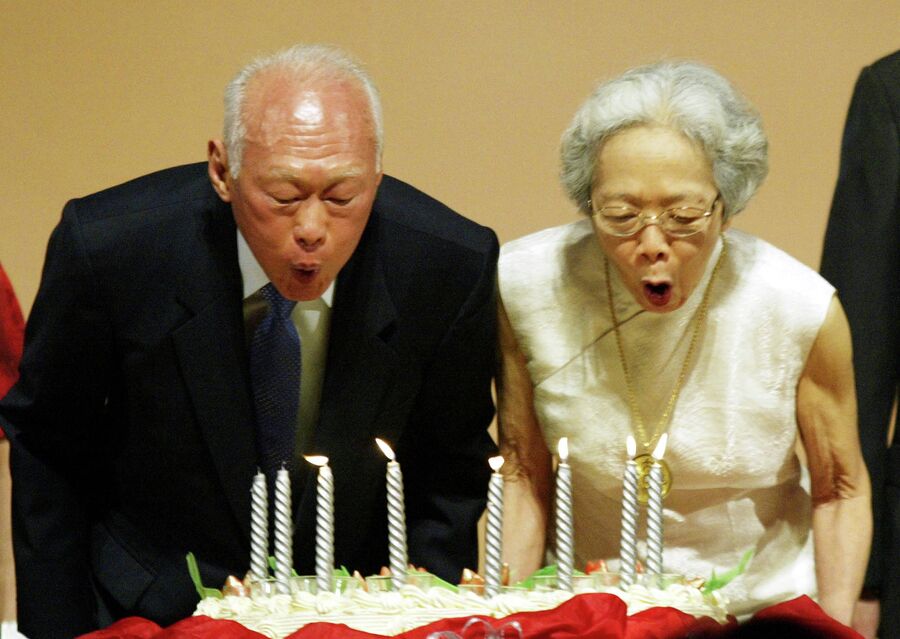 Бывший премьер-министр Сингапура Ли Куан Ю с супругой задувают свечи на праздновании 80-летия