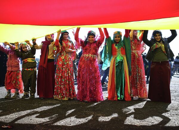 Сторонники курдского лидера Абдуллы Оджалана с курдским флагом во время празднования Навруз в Стамбуле, Турция. 22 марта 2015 год