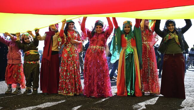 Сторонники курдского лидера Абдуллы Оджалана с курдским флагом во время празднования Навруз в Стамбуле, Турция. 22 марта 2015 год