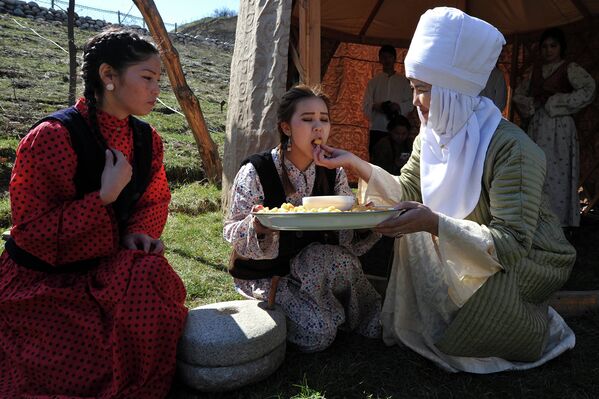 Женщины в традиционных костюмах принимают участие в празднике Навруз в окрестностях столицы Кыргызстана Бишкека. 21 марта 2015 год