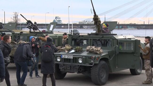 Дети играли с пулеметами на бронетехнике американской военной колонны в Риге