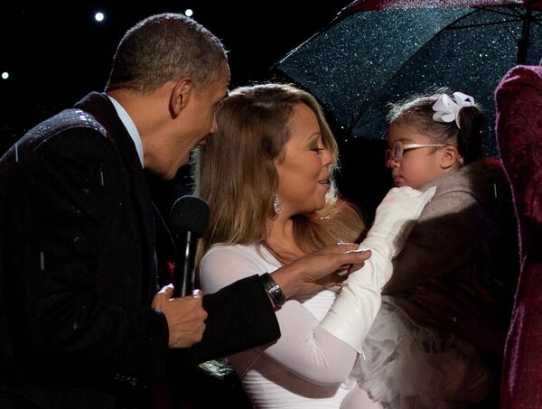 Президент США Барак Обама и певица Мэрайя Кэри с дочерью Монро Кэннон во время церемонии зажжения Национальной рождественской ели