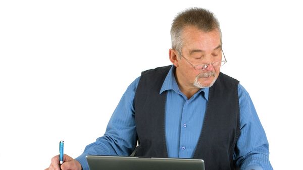Пожилой человек сидит перед компьютером. архивное фото