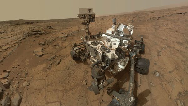 Марсоход Curiosity во время изучения камня Джон Кляйн на поверхности красной планеты
