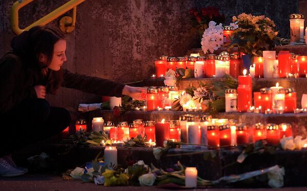 Девушка зажигает свечу в память о погибших пассажирах самолета Airbus A320 авиакомпании Germanwings
