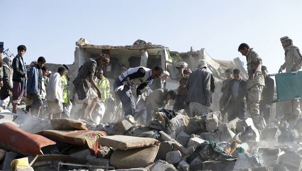 Люди разбирают обломки домов разрушенных при авиаударах вблизи аэропорта Саны