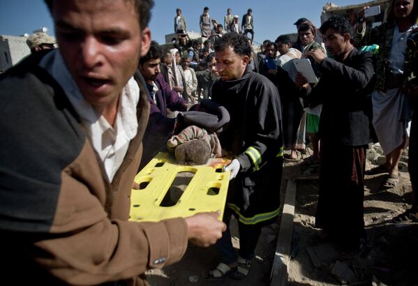 Спасение людей из-под завалов разрушенных домой после авиаударов в Сане, Йемен