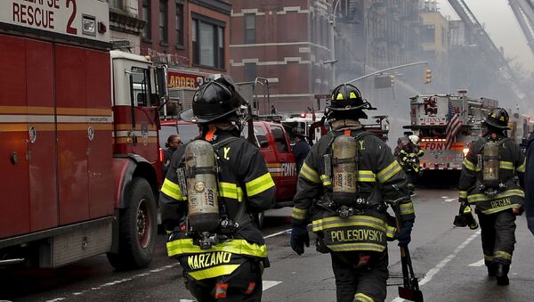 Пожарные работают на месте взрыва газа в жилом доме в Нью-Йорке, США