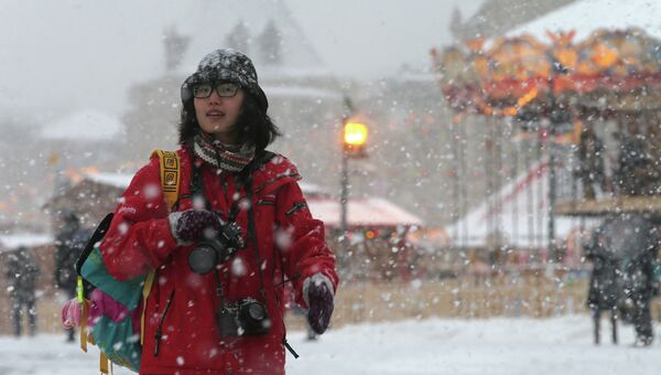 Прохожая на Красной площади во время снегопада в Москве