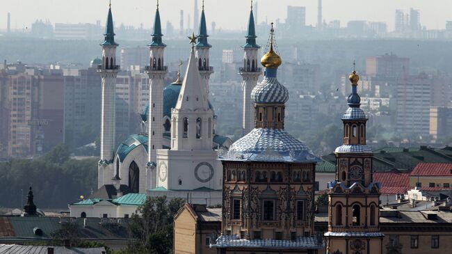 Вид на Петропавловский собор (на первом плане), Спасскую башню Казанского Кремля (в центре) и мечеть Кул Шариф с вертолетной площадки гостиницы Гранд Отель Казань. Архивное фото