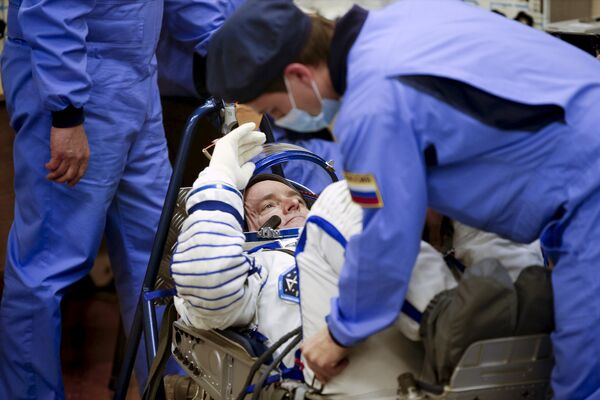 Американский астронавт Скотт Келли во время проверки скафандра перед стартом