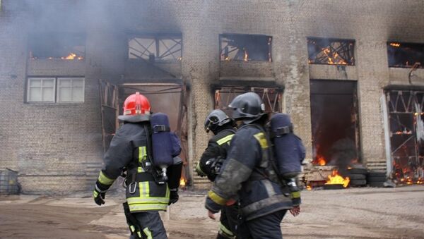 Сотрудники МЧС на месте пожара в производственном здании в Калининском районе Санкт-Петербурга. 31 марта 2015