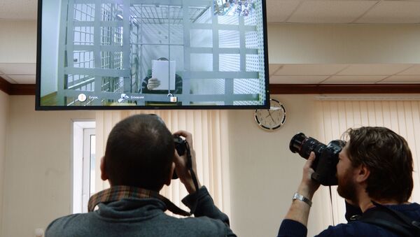 Корреспонденты фотографируют изображение одного из подозреваемых в убийстве политика Бориса Немцова на экране. Архивное фото