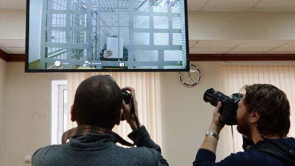 Корреспонденты фотографируют изображение одного из подозреваемых в убийстве политика Бориса Немцова Хамзата Бахаева. 1 апреля 2015