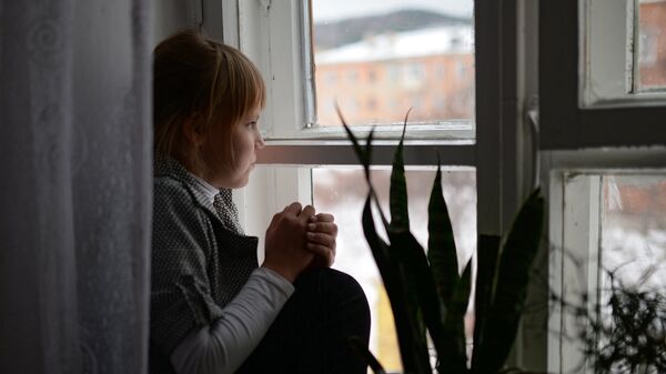 Девочка сидит у окна. Архивное фото