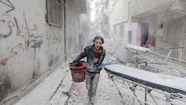 Сирийский подросток в одном из районов Алеппо, пострадавших от бомбардировки