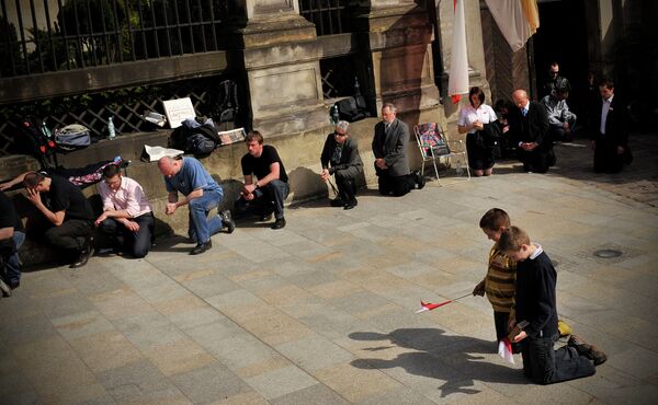 Польский народ молиться на улице во время траурной церемонии в центре Кракова