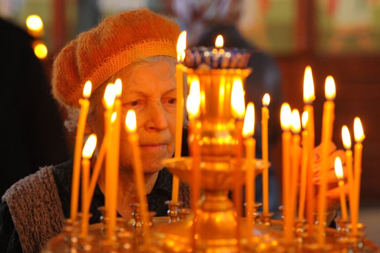 Прихожанка во время богослужения в праздник Входа Господня в Иерусалим в грозненском храме Михаила Архангела