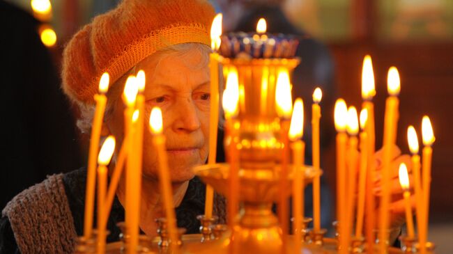 Прихожанка во время богослужения в праздник Входа Господня в Иерусалим в грозненском храме Михаила Архангела