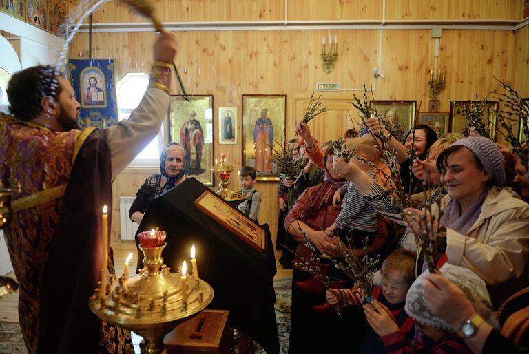 Прихожане во время богослужения в праздник Входа Господня в Иерусалим в храме во имя Казанской иконы Божией матери в поселке Калиново