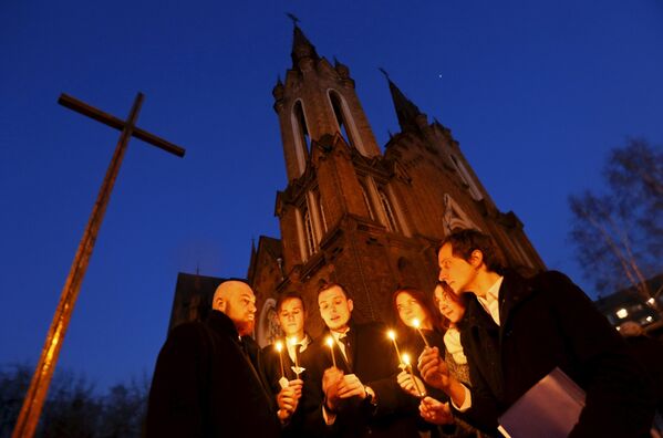 Католики Красноярска держат свечи во время службы Святой субботы накануне Пасхи