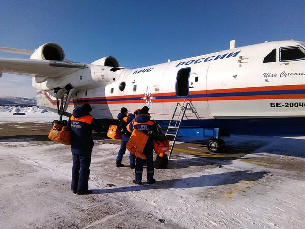 Сотрудники МЧС РФ садятся на борт самолёта Бе-200 для участия в поисково-спасательной операции в районе крушения траулера Дальний Восток в Охотском море