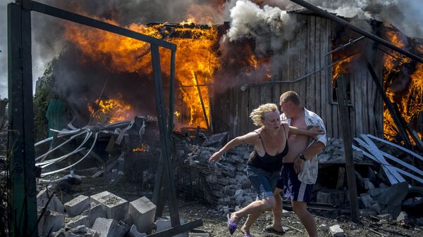Местные жители спасаются от пожара, возникшего в результате авиационного удара вооруженных сил Украины по станице Луганская, 2 июля 2014. Архивное фото