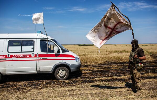 Украинский военный с белым флагом во время передачи убитых на нейтральной территории вблизи поселка Диброво возле российско-украинской границы в Донецкой области, 29 июля 2014