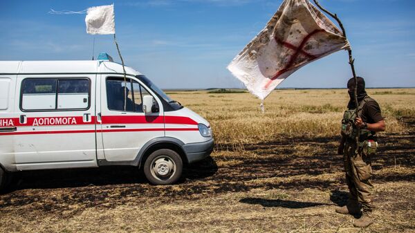 Украинский военный с белым флагом во время передачи убитых на нейтральной территории вблизи поселка Диброво возле российско-украинской границы в Донецкой области, 29 июля 2014