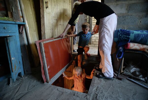 Семья спускается в подвал частного дома оборудованный под бомбоубежище в Краматорске Донецкой области