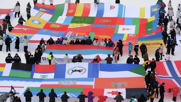 Участники высокоширотной полярной экспедиции в рамках проекта Арктика - 2015 демонстрируют единым полотном флаг России, флаг Норвегии, флаг Сербии и флаги 85 субъектов Российской Федерации в шахтерском городе Баренцбург на архипелаге Шпицберген