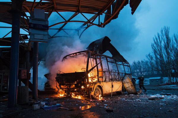 Автобус, поврежденный в результате обстрела, на автостанции в городе Донецке