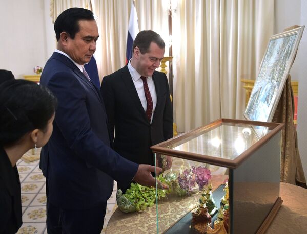 Председатель правительства России Дмитрий Медведев и премьер-министр Тайланда Праюта Чан-Очи обмениваются подарками во время встречи в Доме правительства Тайланда