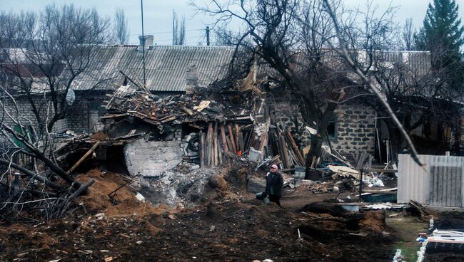 Женщина возле разрушенного дома в Углегорске, Украина. Архивное фото