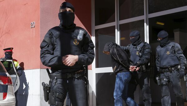 Каталонский полицейский у дома задержанного подозреваемого во время операции против исламистских боевиков