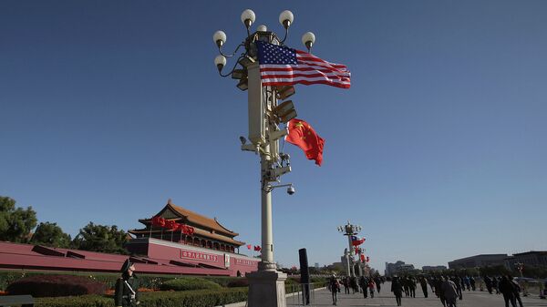 Военный смотрит на флаги США и Китая возле входа в Запретный город в Пекине