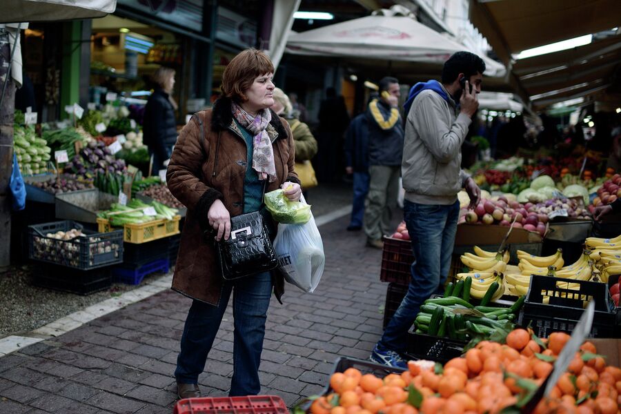 Покупатели в овощном отделе на центральном рынке в Афинах, Греция