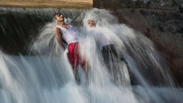 Мужчины купаются в потоке воды на окраине Исламабада. Архивное фото