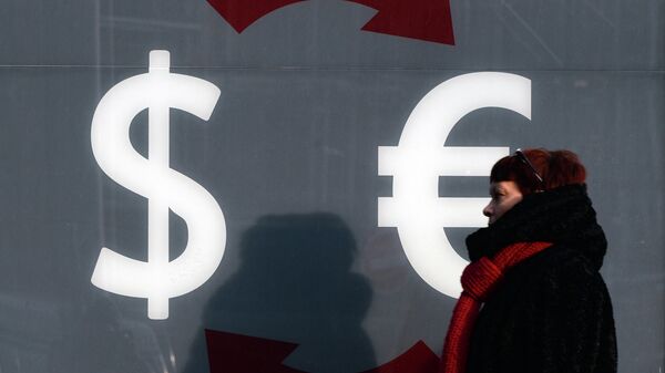 Знаки доллара и евро на стене пункта обмена валюты в Москве